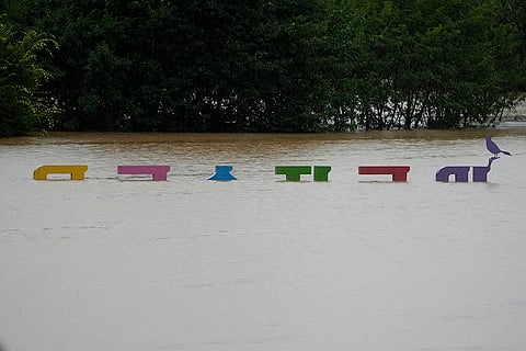 Logo of a park is partially submerged in flood waters